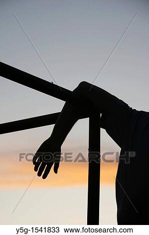 Stock Image - man performing parkour on roof top in city town at night. Fotosearch
