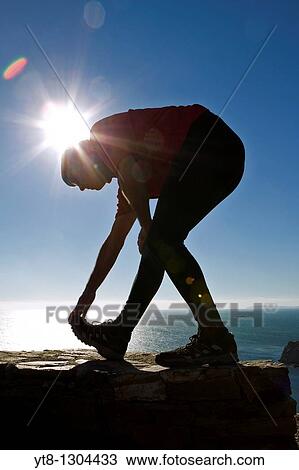 Man performing stretching exercise by the sea View Large Photo Image Stock Image - Man performing stretching exercise by the sea. Fotosearch