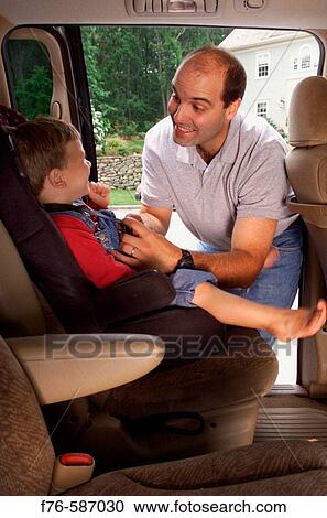 Man placing / buckling in his 3 year old son in child seat in rear of vehicle. View Large Photo Image Stock Image - Man placing / buckling in his 3 year old son in child seat in rear of vehicle.. Fotosearch