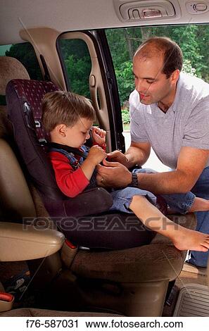 Man placing / buckling in his 3 year old son in child seat in rear of vehicle. View Large Photo Image Stock Image - Man placing / buckling in his 3 year old son in child seat in rear of vehicle.. Fotosearch