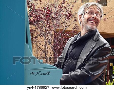 Man playing a piano outdoors View Large Photo Image Stock Photo - Man playing a piano outdoors. Fotosearch