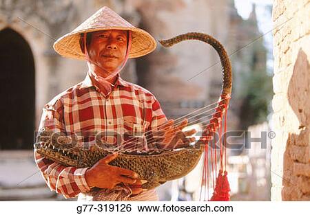 Stock Photograph - Man playing the Burmese harp. Bagan. Myanmar (Burma). Fotosearch