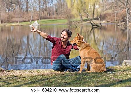 Man playing with dog in park View Large Photo Image Stock Image - Man playing with dog in park. Fotosearch