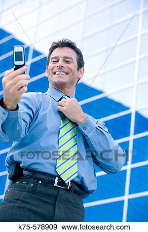 Man posing for his own photo on camera phone View Large Photo Image Stock Photo - Man posing for his own photo on camera phone. Fotosearch