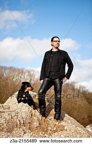 Stock Photo - Man posing with dog in a barren landscape, Strijp-R, Eindhoven.. Fotosearch