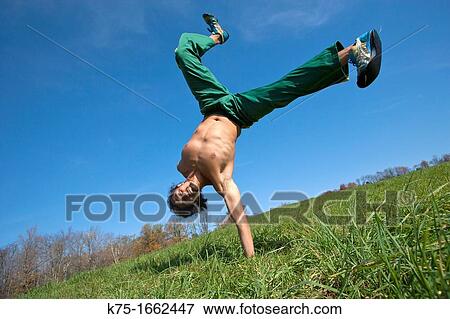 Man practicing capoeira in field View Large Photo Image Stock Photo - Man practicing capoeira in field. Fotosearch