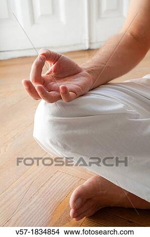 Picture - Man practising yoga, sitting in the lotus position. Close view.. Fotosearch