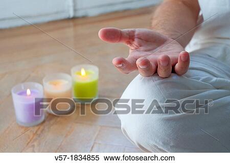 Stock Photography - Man practising yoga, sitting in the lotus position. Close view.. Fotosearch