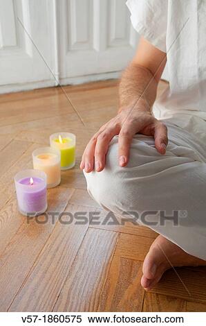 Stock Photography - Man practising yoga, sitting in the lotus position. Close view.. Fotosearch