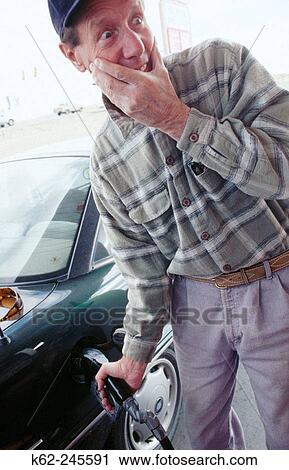 Man pumping gas and gasping at price View Large Photo Image Stock Image - Man pumping gas and gasping at price. Fotosearch