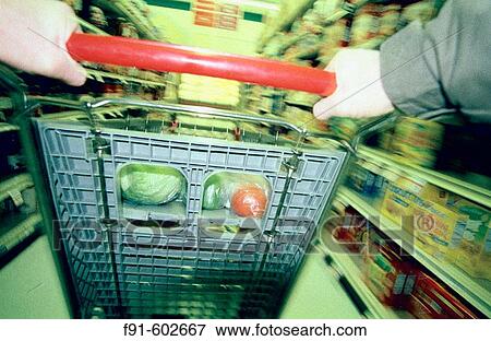 Man pushing shopping cart in grocery store View Large Photo Image Stock Photo - Man pushing shopping cart in grocery store. Fotosearch