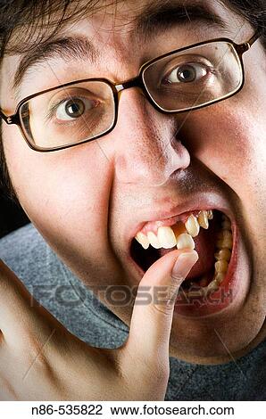 Stock Image - Man putting in a false front tooth. Fotosearch