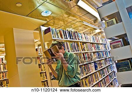Man reading a book in the library View Large Photo Image Picture - Man reading a book in the library. Fotosearch