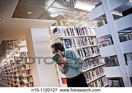 Man reading a book in the library View Large Photo Image Stock Photo - Man reading a book in the library. Fotosearch