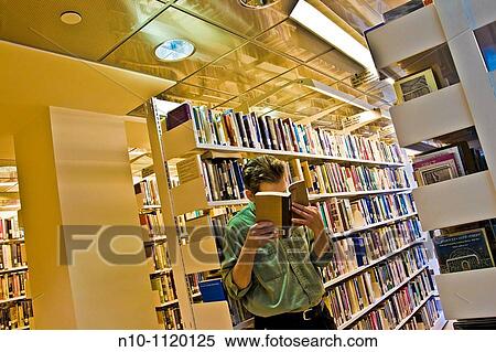 Man reading a book in the library View Large Photo Image Stock Photography - Man reading a book in the library. Fotosearch
