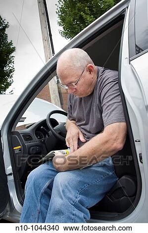 Man reading the car's manual while sitting in his car View Large Photo Image Stock Image - Man reading the car's manual while sitting in his car. Fotosearch