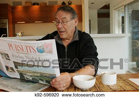Man reading the newspaper in the kitchen View Large Photo Image Stock Image - Man reading the newspaper in the kitchen. Fotosearch