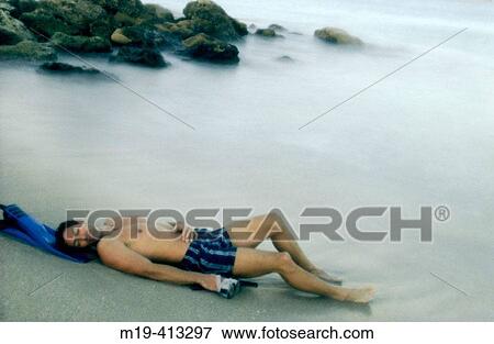 man reclined on a misty beach View Large Photo Image Stock Photo - man reclined on a misty beach. Fotosearch