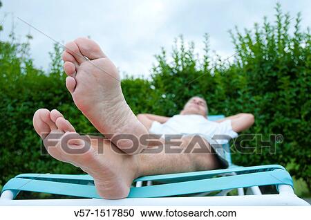 Stock Image - Man relaxing in a deck chair. Fotosearch