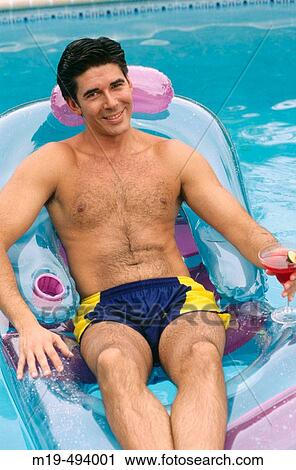 Stock Image - man relaxing in a swiming pool. Fotosearch