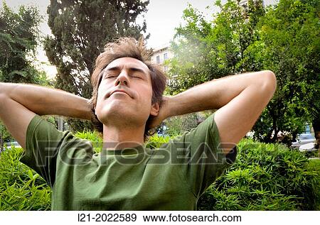 Stock Photo - Man relaxing in public garden.. Fotosearch