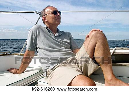 Man relaxing on a sailboat View Large Photo Image Stock Image - Man relaxing on a sailboat. Fotosearch