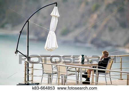 Stock Image - Man relaxing on terrace. Fotosearch