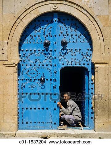 Man repairing a traditional blue studded door, Sidi Bou Said village, Tunisia View Large Photo Image Picture - Man repairing a traditional blue studded door, Sidi Bou Said village, Tunisia. Fotosearch