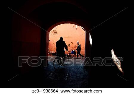 Man riding a bicycle and passing through a passage in Marrakech medina, Morocco. View Large Photo Image Picture - Man riding a bicycle and passing through a passage in Marrakech medina, Morocco.. Fotosearch