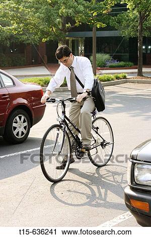 Man riding a bicycle arriving at work in the morning View Large Photo Image Stock Image - Man riding a bicycle arriving at work in the morning. Fotosearch