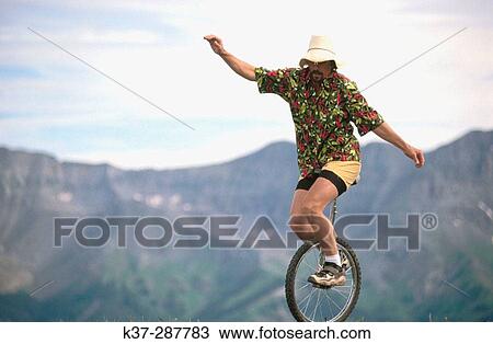 Man riding unicycle on mountain path. Colorado. USA View Large Photo Image Stock Image - Man riding unicycle on mountain path. Colorado. USA. Fotosearch