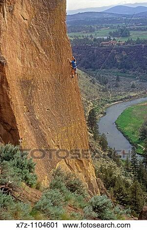 Stock Image - Man, rock climbing Moons Of Pluto high above The Crooked River at Smith Rock State Park, Oregon. Fotosearch