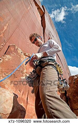 Man ropeing up to rock climb a route called Amaretto Corner which is rated 5, 9 and located on Super Crack Buttress at Indian Creek Canyon in southern Utah USA View Large Photo Image Stock Image - Man ropeing up to rock climb a route called Amaretto Corner which is rated 5, 9 and located on Super Crack Buttress at Indian Creek Canyon in southern Utah USA. Fotosearch