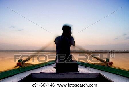 Man rowing boat on the Ganges at dawn, Varanasi. Uttar Pradesh, India View Large Photo Image Stock Photograph - Man rowing boat on the Ganges at dawn, Varanasi. Uttar Pradesh, India. Fotosearch