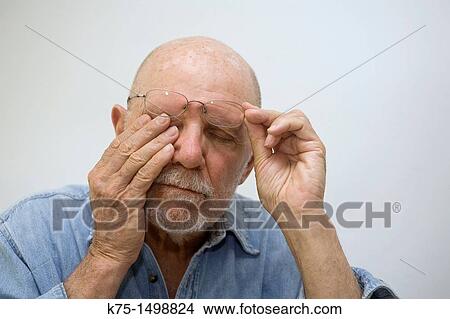 Picture - Man rubbing his eyes. Fotosearch