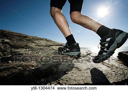 Man running along a rocky coastal path View Large Photo Image Picture - Man running along a rocky coastal path. Fotosearch