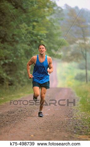 Man running down country road View Large Photo Image Stock Photo - Man running down country road. Fotosearch