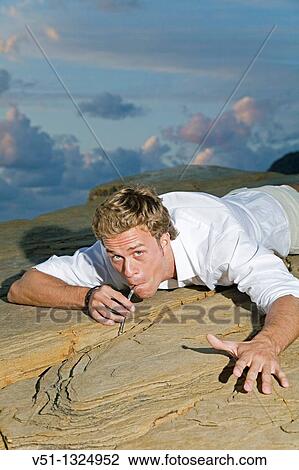 Stock Image - Man searching water through the rocks. Fotosearch