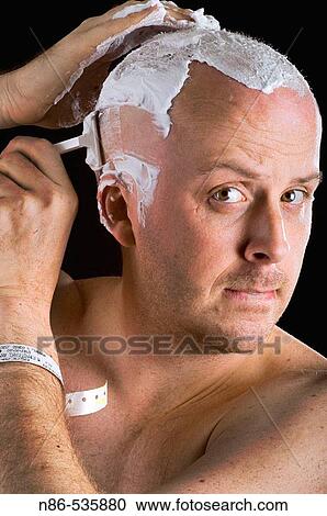 Man shaving head in front of mirror View Large Photo Image Stock Image - Man shaving head in front of mirror. Fotosearch
