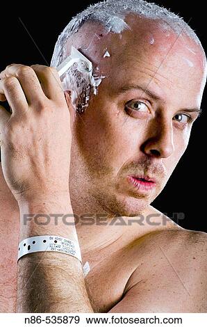 Stock Photo - Man shaving head in front of mirror. Fotosearch