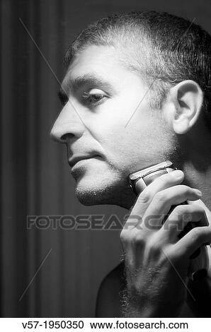 Stock Image - Man shaving his beard. Black and white.. Fotosearch
