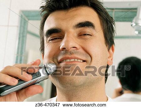 Stock Photo - Man shaving in bathroom. Fotosearch