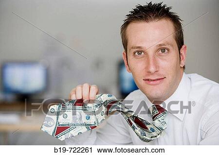 Stock Image - Man showing his dollar-pattern tie. Fotosearch
