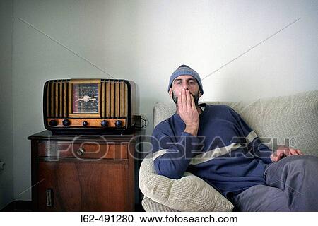 Man sitting in his sofa. View Large Photo Image Stock Image - Man sitting in his sofa.. Fotosearch