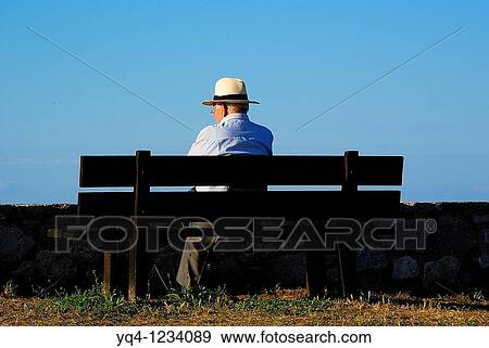 Man sitting on a bench in the Paseo de San Pedro, Llanes, Asturias View Large Photo Image Stock Photo - Man sitting on a bench in the Paseo de San Pedro, Llanes, Asturias. Fotosearch