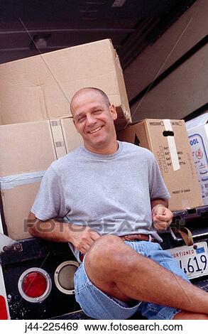 Man sitting on a moving truck deck smiling View Large Photo Image Stock Photo - Man sitting on a moving truck deck smiling. Fotosearch