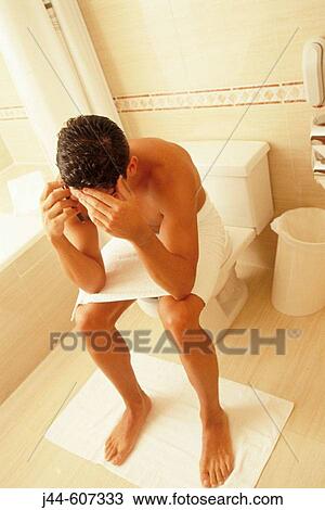Man sitting on a toilet while talking on cellular phone View Large Photo Image Stock Image - Man sitting on a toilet while talking on cellular phone. Fotosearch
