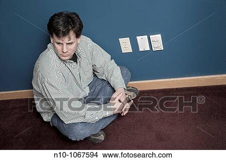 Man sitting on his office floor next to three outlets View Large Photo Image Picture - Man sitting on his office floor next to three outlets. Fotosearch