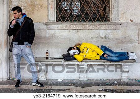 Man Sleeping On A Public Bench, St Mark's Square, Venice Carnival, Venice, Italy. View Large Photo Image Stock Photo - Man Sleeping On A Public Bench, St Mark's Square, Venice Carnival, Venice, Italy.. Fotosearch