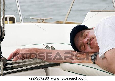 Man sleeping on a sailboat View Large Photo Image Stock Image - Man sleeping on a sailboat. Fotosearch
